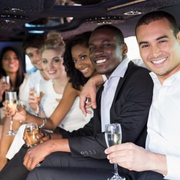 adults driving to a rehearsal dinner in a limousine