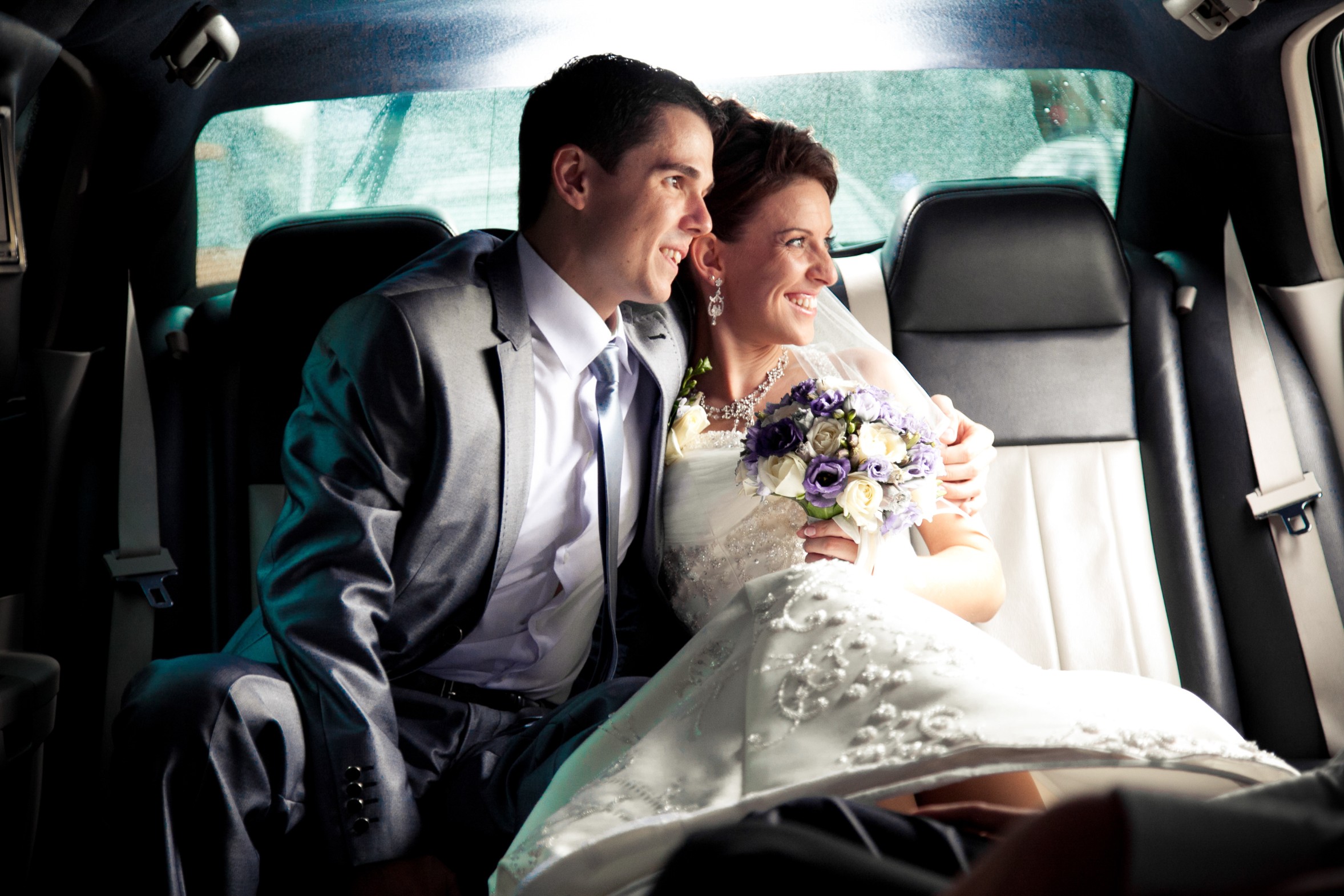 bride and groom in limo to airport